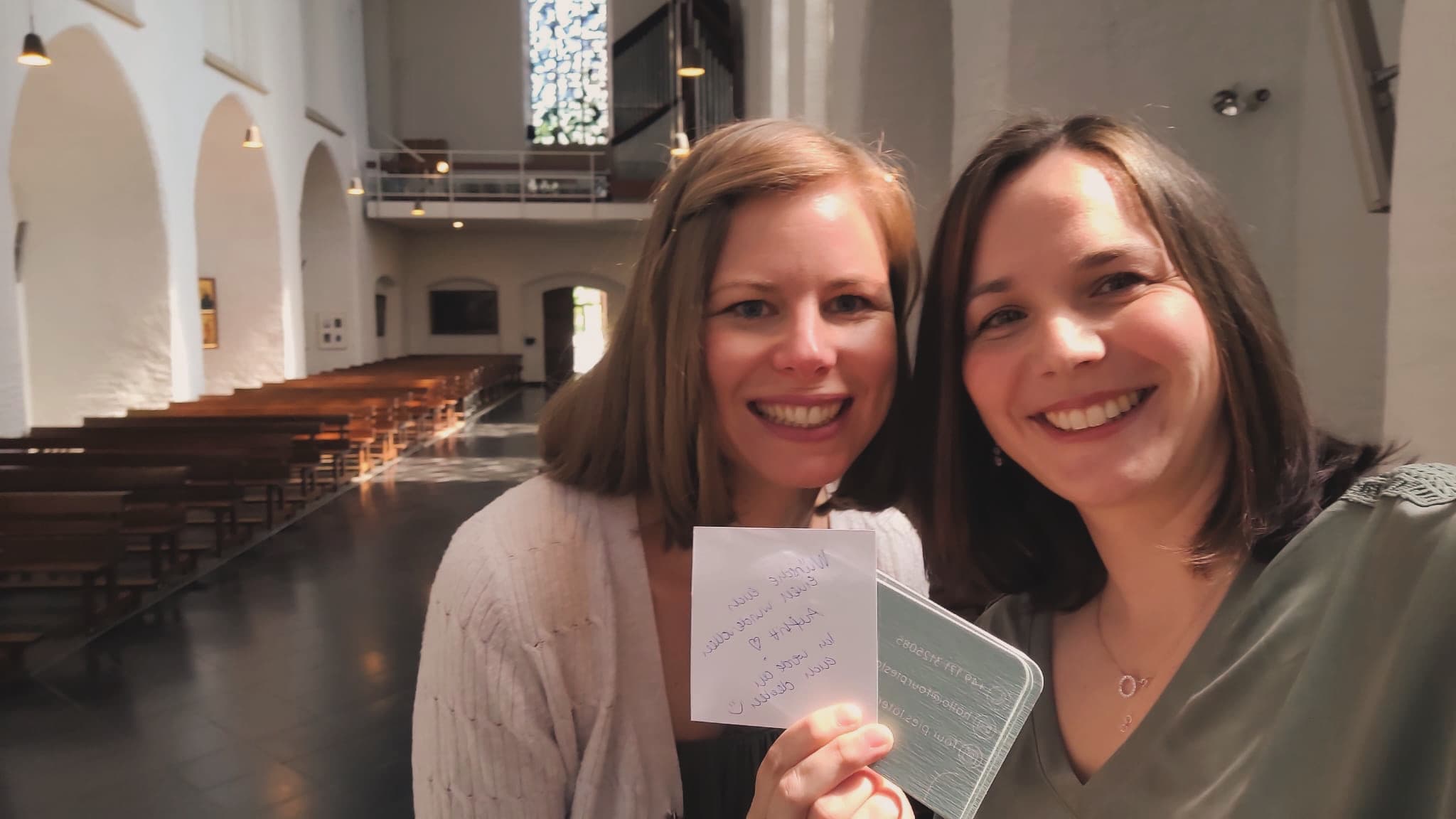 Zwei Sängerinnen von Four Pies Later in der Kirche mit Valentinas handgeschriebenem Glückwunsch-Zettel